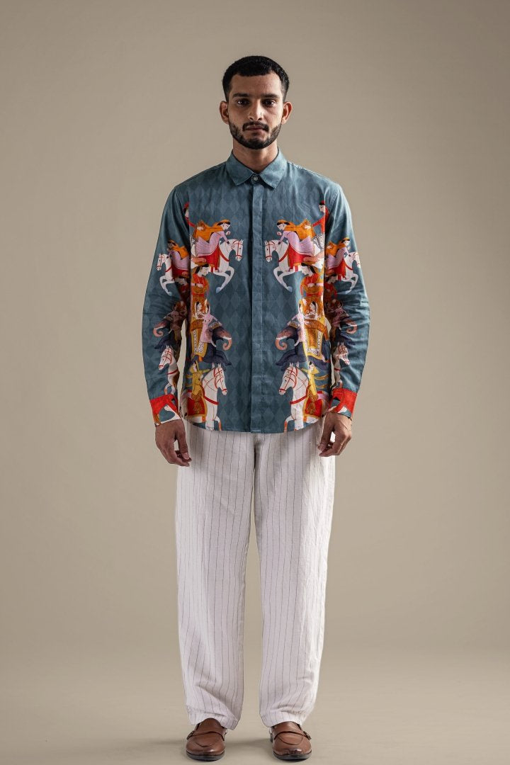 Man wearing the blue Kirtharjuna shirt with white trousers, front view