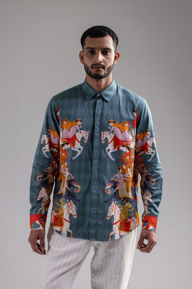Man wearing the blue Kirtharjuna shirt, waist-up front view