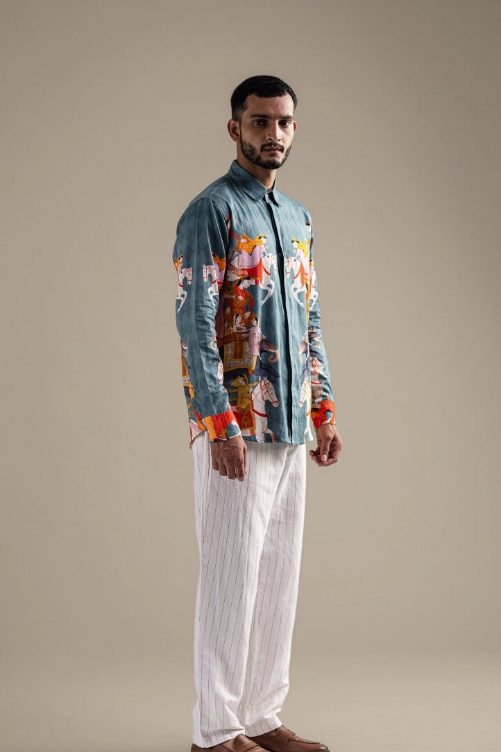 Man wearing the Kirtharjuna shirt with white trousers, full length three-quarter view