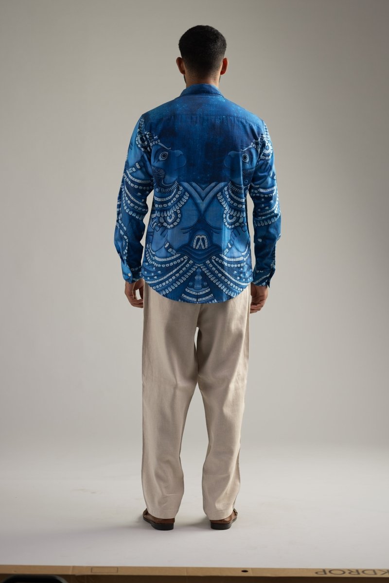 Man wearing the indigo blue Vanaryugalam shirt with cream trousers, back view