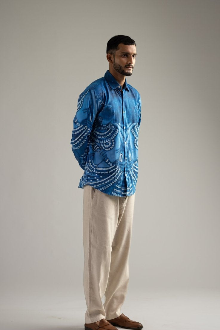 Man wearing the Vanaryugalam shirt with cream trousers, full length side view